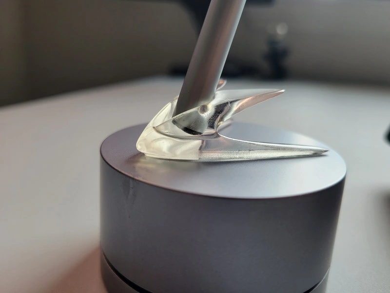Physical resin prototype holding a pen on a separate display stand, archive photograph